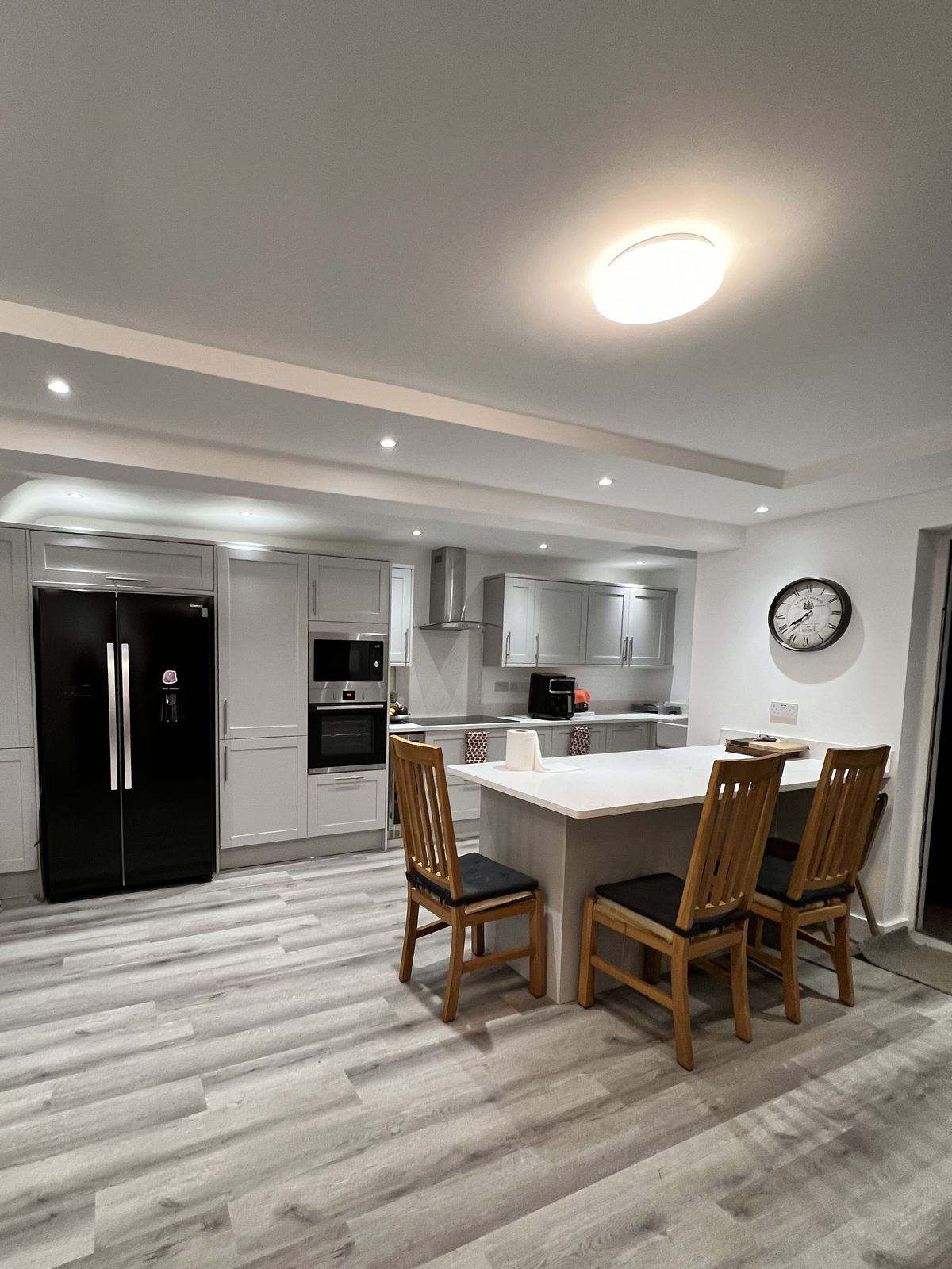 A freshly finished open-plan kitchen and dining room with grey shaker units and a breakfast island